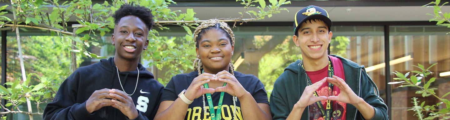 2023-24 New Student Fall Retreaters pose and make the "O" sign with their hands.