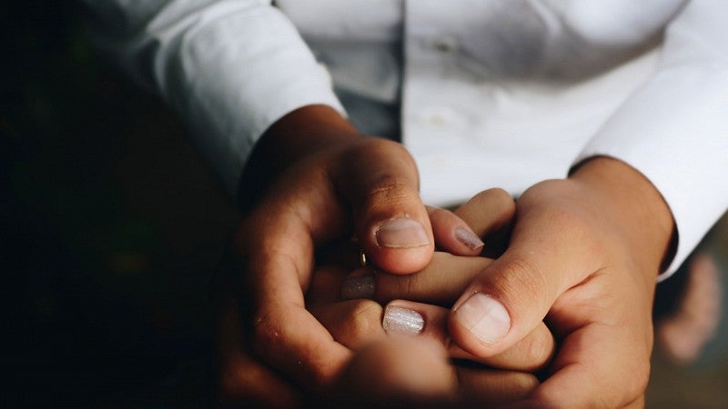 Ethics of care lace photos Person holding hands with other smaller hands